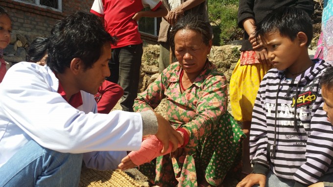 Medical Person helping an earthquake survivor at Simpani Village