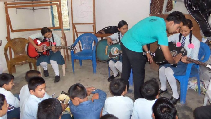 Music Teacher Showing Scholars How to Play Guitar