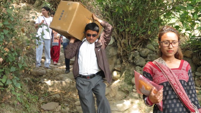 Program Officer Niroj Shrestha carries medicine box