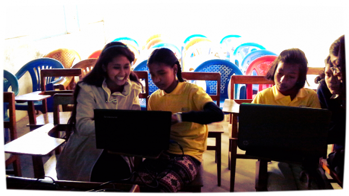 Girls learning how to use PowePoint for presenting their story