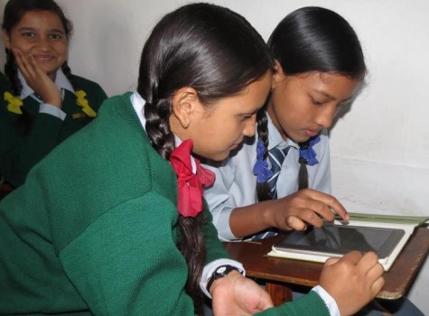 Puja is waiting patiently for her turn to use the new eBook reader