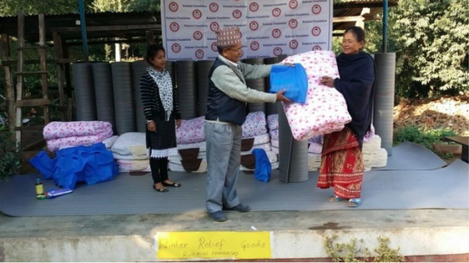 Head of Student Selection Committee Mr. Kedar Nath Acharya handing over winter relief supplies