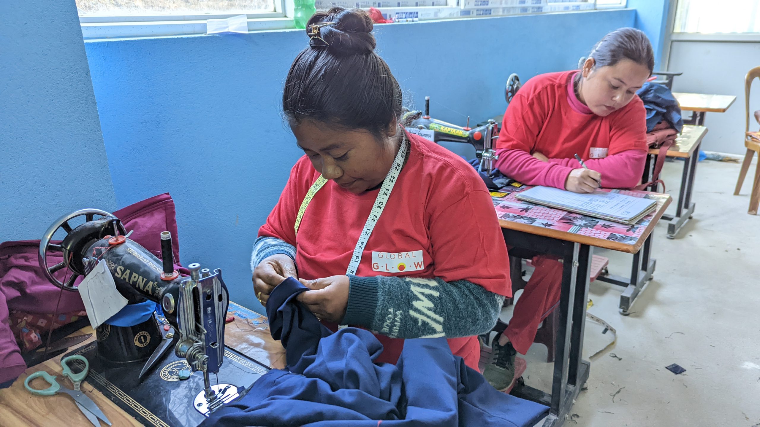 Trainee Mangal Kumari sewing the school uniform during training