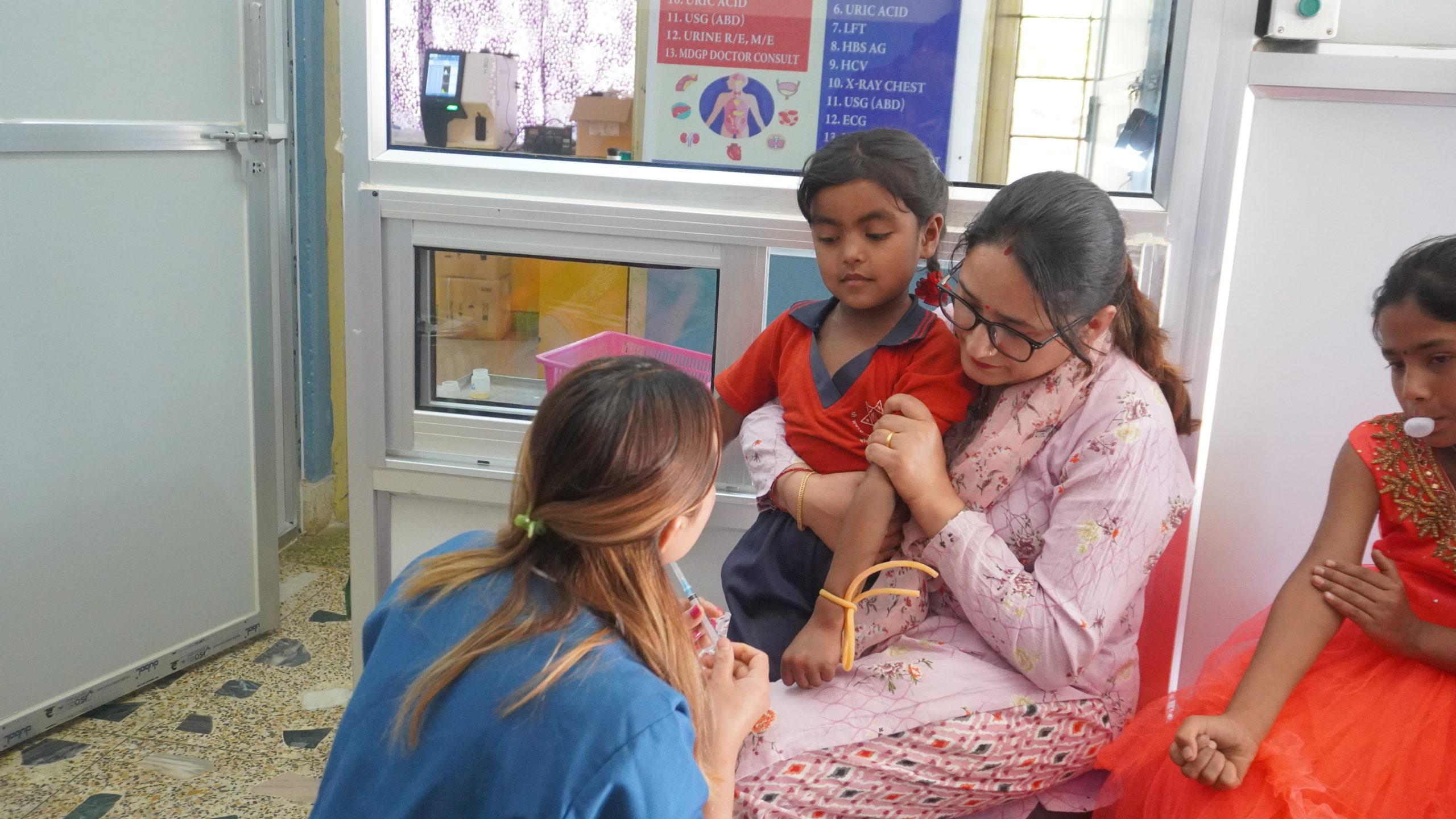 _Dipa Didi assisting the nurse with blood check-ups and offering emotional support to the Bahinis