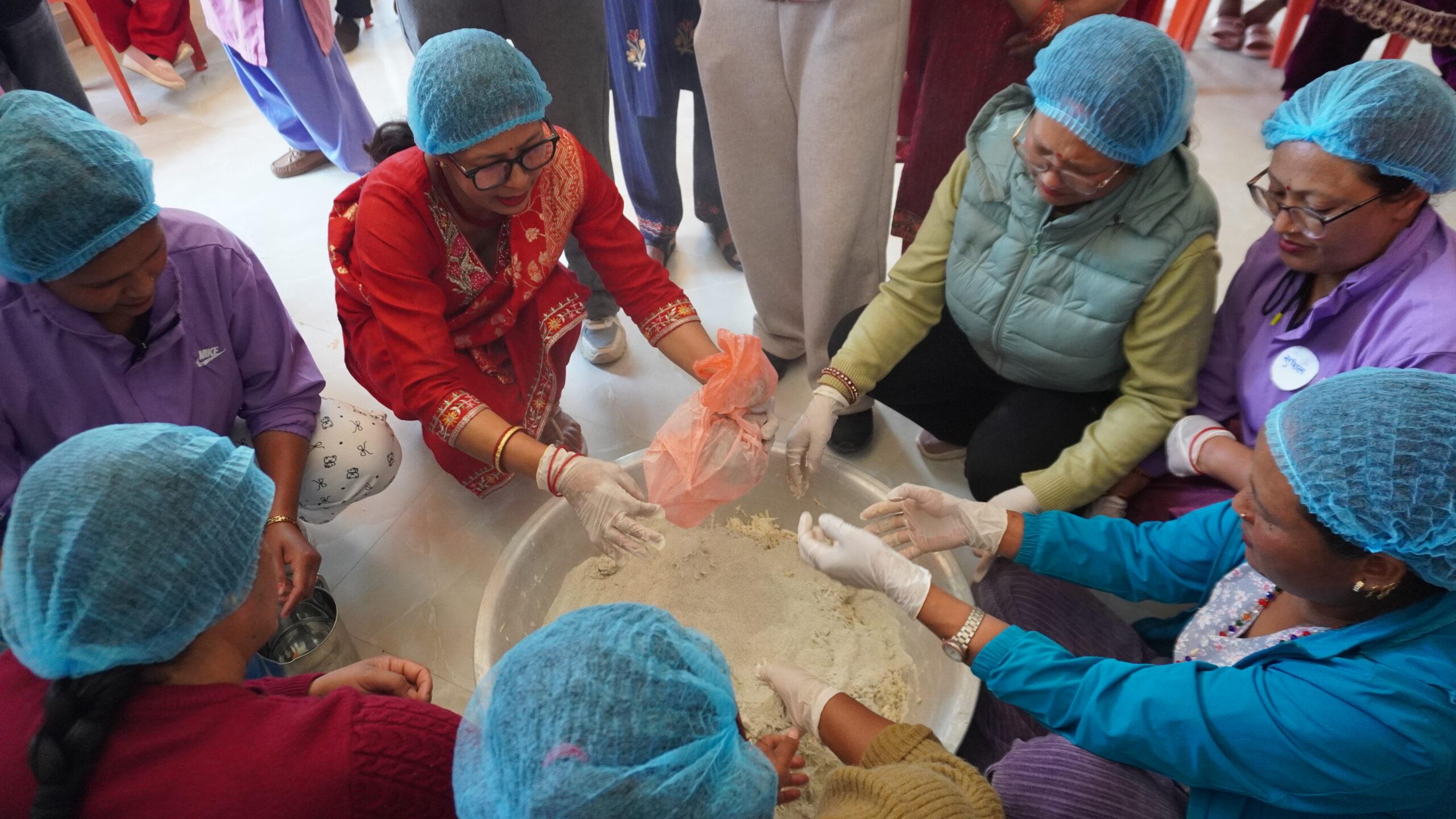 Adding lentil flour to grated taro to prepare traditional masyaura_